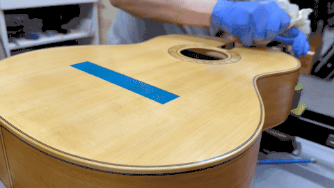Luthier French polishing the guitar